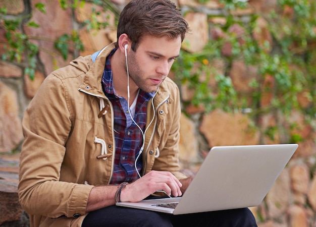 C'est un étudiant dévoué Photo d'un bel étudiant utilisant son ordinateur portable sur le campus