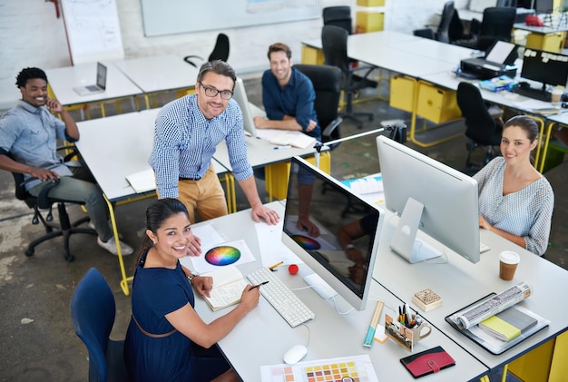 C'est là que nous nous mettons au travail Portrait en grand angle d'un groupe de designers travaillant sur leur ordinateur dans un bureau