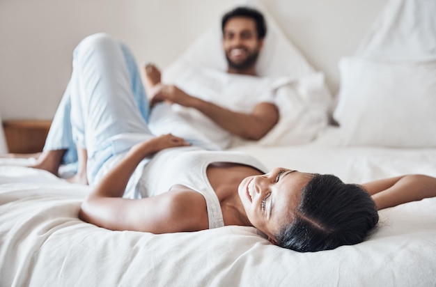 C'est l'un de leurs jours paresseux à la maison Photo d'un jeune couple allongé sur un lit ensemble à la maison