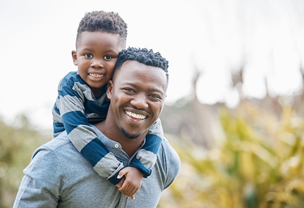 C'est mon petit champion Photo d'un jeune père se liant avec son fils et lui faisant faire un tour de ferroutage dans le jardin