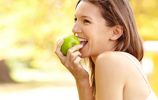 C'est plus qu'une simple pomme Photo d'une jolie jeune femme dans le parc un jour d'automne