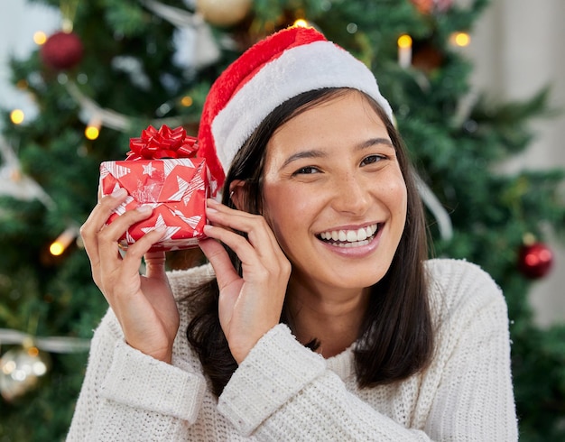 Est-ce que ça fait du bruit Photo d'une jeune femme tenant un cadeau à la maison