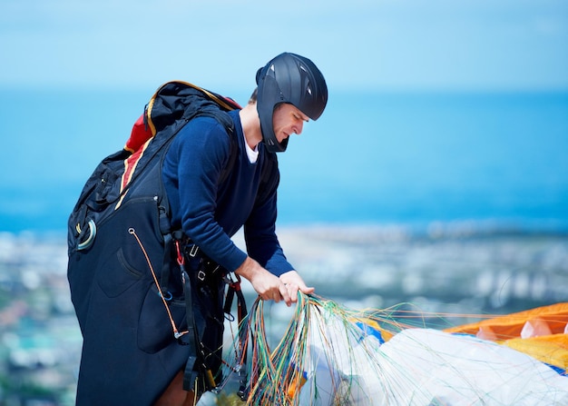 Est-ce que tout est assez serré Plan d'un homme se préparant à faire du parapente