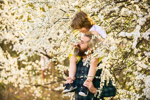 C'est tout simplement incroyable, amusez-vous juste avec le concept d'amour Joyeux père jouant avec un enfant dans le parc Beau papa avec un petit fils mignon profiter de la floraison et de la nature ensemble bonne journée en famille le printemps arrive