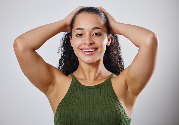 C'est vos cheveux, prenez-en soin Photo recadrée d'une femme touchant ses cheveux mouillés sur un fond gris