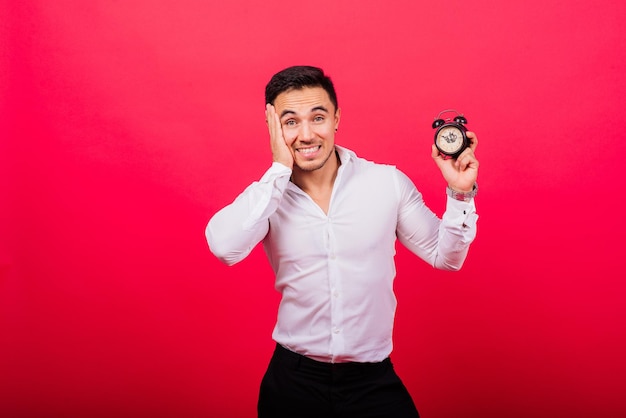 C'est votre temps portrait de jeune homme en montrant l'heure sur l'horloge montre ok pouce vers le haut approuver