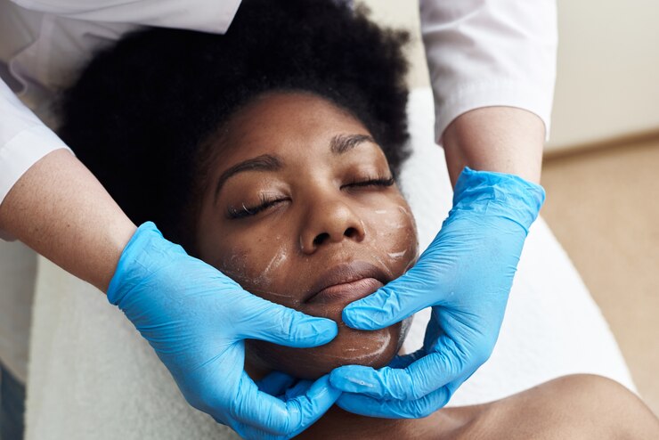 Esthéticienne appliquant une crème hydratante sur un client
