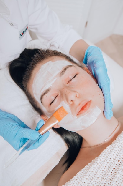 Esthéticienne appliquant un masque facial sur une cliente