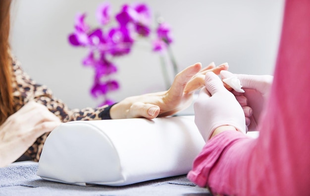 Photo esthéticienne enlevant le vernis à ongles