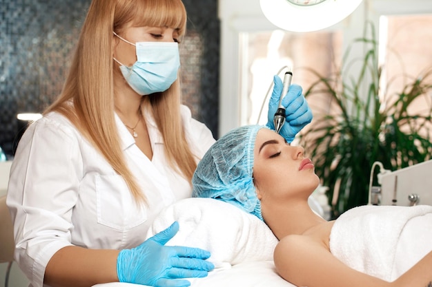 L'esthéticienne fait le nettoyage du visage dans le salon de spa