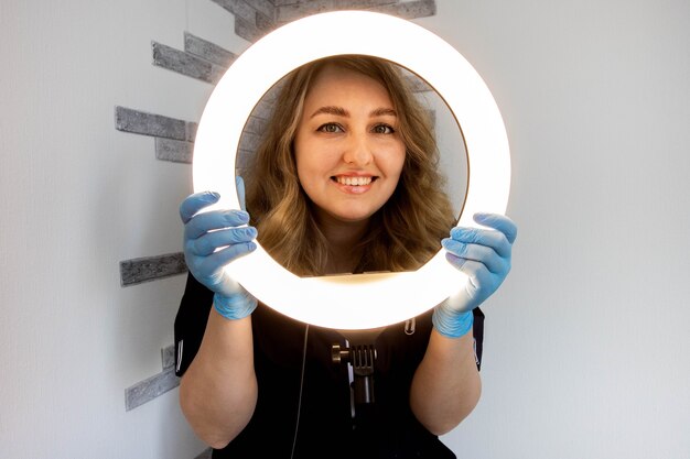 Photo esthéticienne fille avec lampe à anneau.