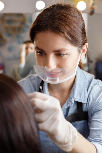 Esthéticienne peignant les sourcils à la femme