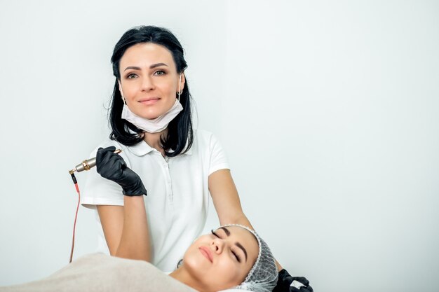 Esthéticienne travaillant pendant la procédure d'extension des cils avec le patient