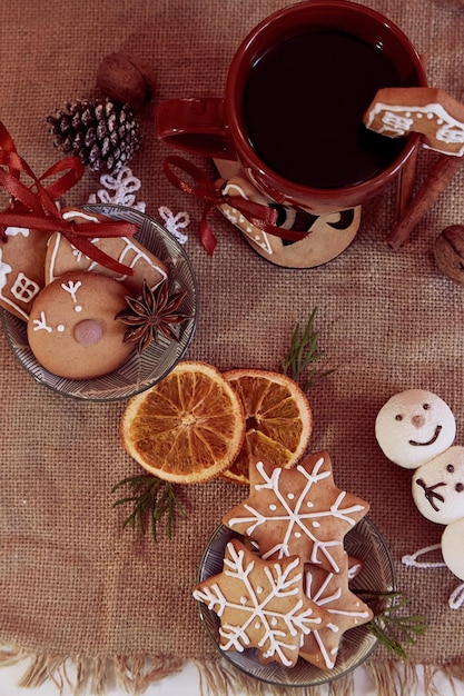 Esthétique de la nourriture de Noël avec des décorations tasse de café biscuits au pain d'épice mandarines sur toile de jute