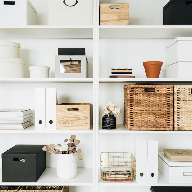 Etagères de rangement blanches avec boîtes, eucalyptus, décorations. Chambre de style scandinave.