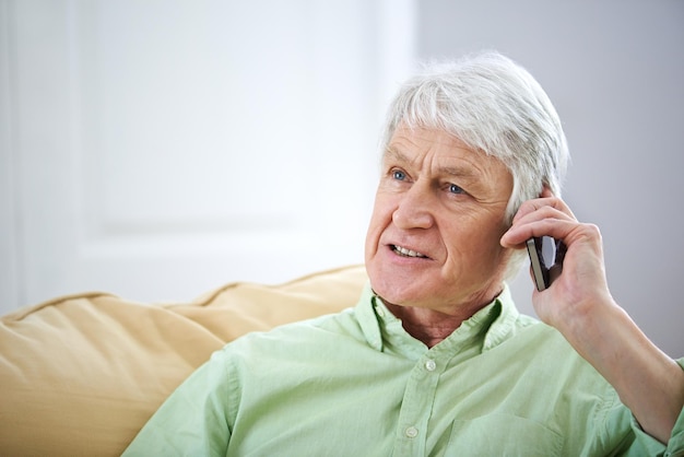 C'était super de te revoir. Photo d'un homme âgé parlant sur son téléphone portable à la maison.