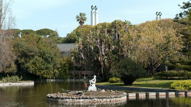 Photo un étang avec une statue au premier plan et un bâtiment en arrière-plan