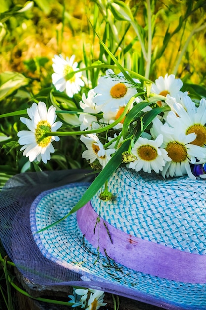 En été, Un Chapeau Et Un Bouquet De Fleurs Sont Allongés Sur Un Pré Vert, De L'herbe