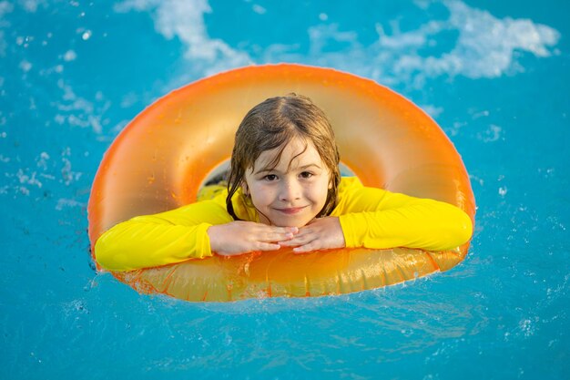 L'été, c'est marrant. Le petit enfant nage dans la piscine. L'enfant dans la piscina.