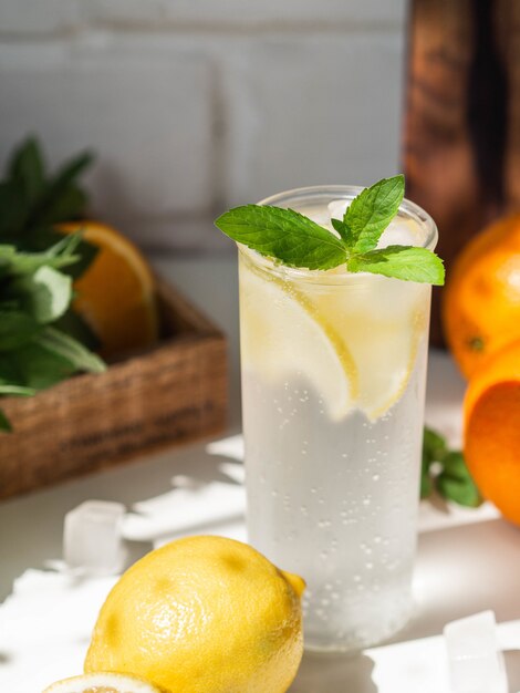 Été frais limonade aux agrumes maison avec de la glace en verre sur un tableau blanc.