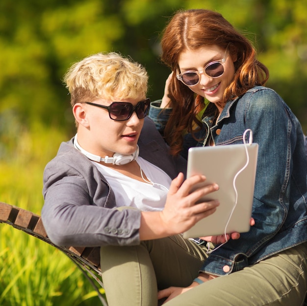 été, internet, éducation, campus et concept d'adolescent - étudiants ou adolescents avec un ordinateur tablette traînant