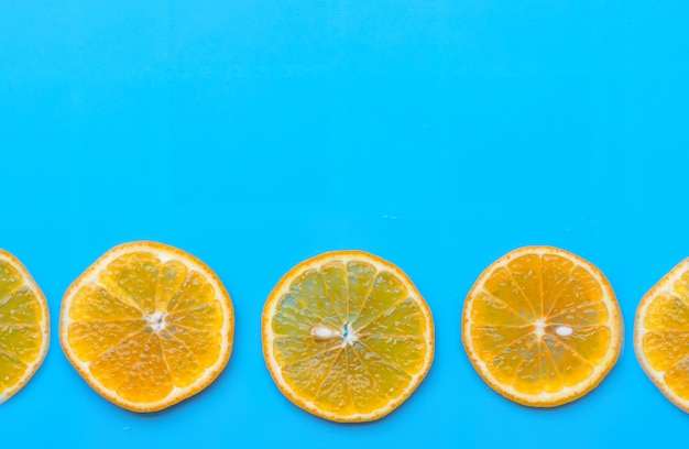 Photo Été de tranche de fruits orange sur fond bleu.