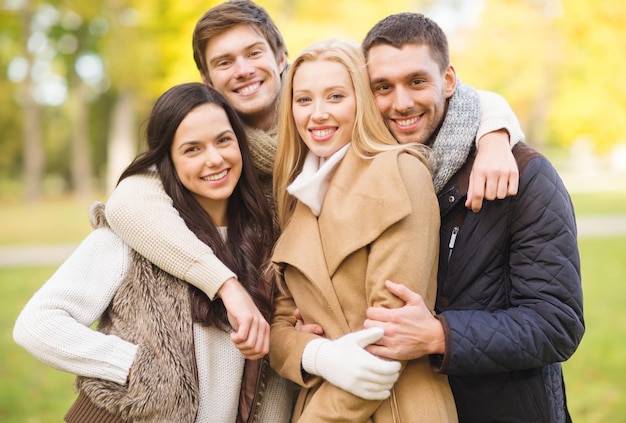 été, vacances, vacances, concept de gens heureux - groupe d'amis ou de couples s'amusant dans le parc d'automne