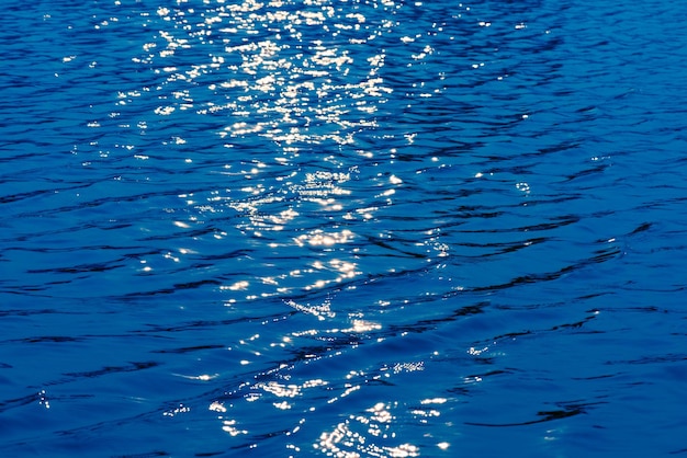 Une étendue d'eau bleue avec le soleil qui brille dessus.