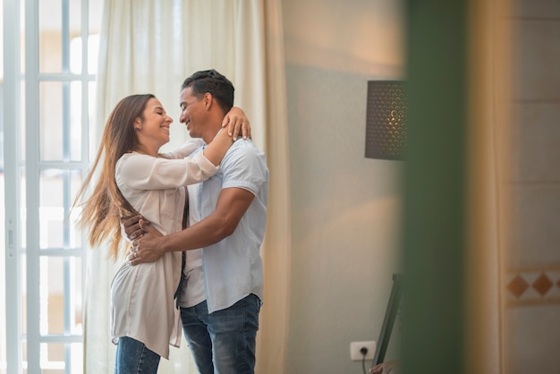 Une ethnie métisse heureuse à la maison se sent excitée danser et tenir avec amusement, sourire fou de joie couple aime célébrer l'anniversaire tourbillonnant et dansant ensemble dans l'amour et la relation