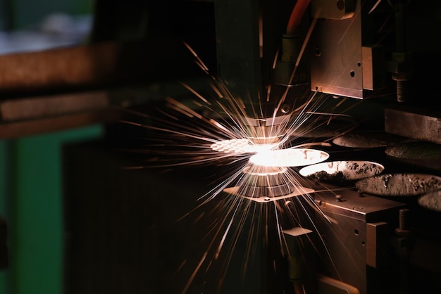 Des étincelles jaillissent de la tête de machine pour le traitement des métaux au laser