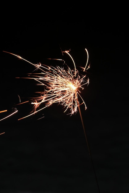 Des étincelles lumineuses la nuit Brûlant des cierges magiques bougie de feu du Bengale sur fond noir foncé Lumières étincelantes au Nouvel An Noël Vacances de Noël