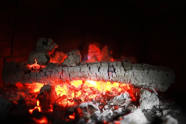 Des étincelles rouges brûlantes volent d'un grand feu. Des charbons ardents, des particules enflammées s'envolant sur fond noir.