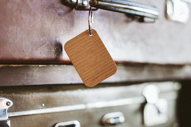 Etiquette de bagage en bois sur le manche d'une vieille valise.