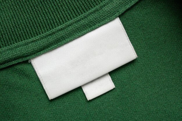 Étiquette blanche de vêtements de blanchisserie sur fond de texture de tissu de chemise verte