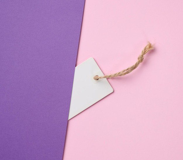 Étiquette de papier blanc vide sur une corde fond rose Vue de dessus du modèle de prix