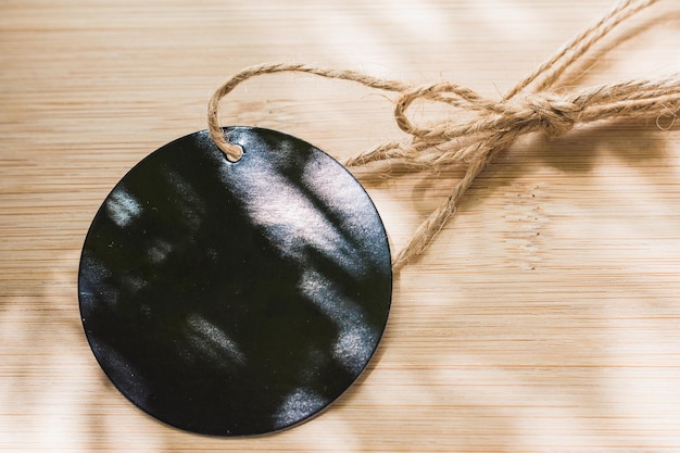 Etiquette ronde noire avec cordon marron en matière naturelle vide pour mettre une image de marque ou commerciale