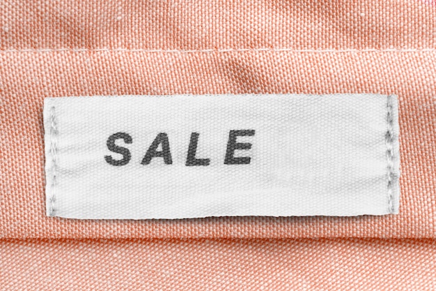 L'étiquette de vêtements dit vente sur fond textile beige libre