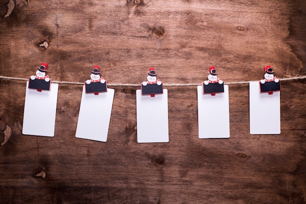 Photo Étiquettes en papier suspendues à une corde accrochées à des pinces à linge décoratives de noël