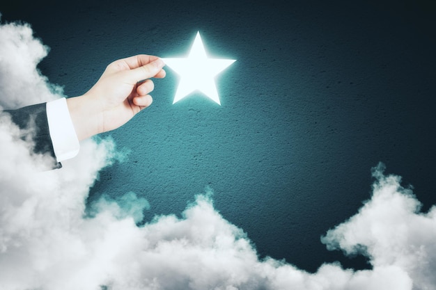L'étoile brillante tenue à la main sur un fond bleu abstrait avec un nuage Concept d'imagination
