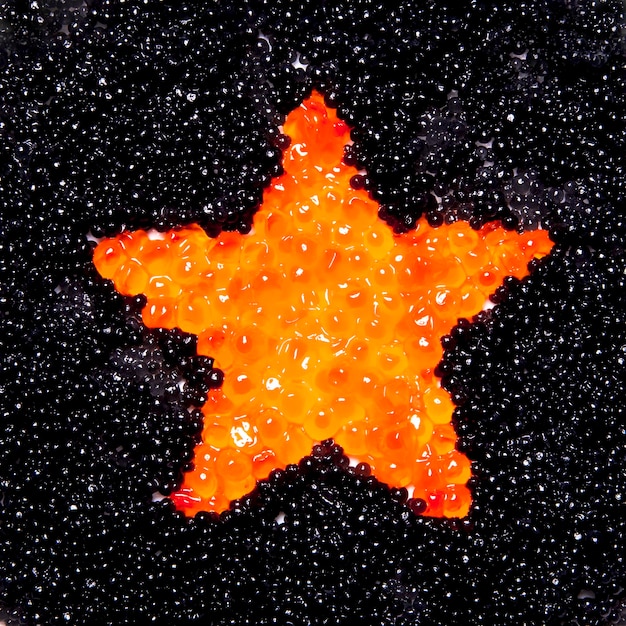 L'étoile du caviar rouge sur fond de caviar noir