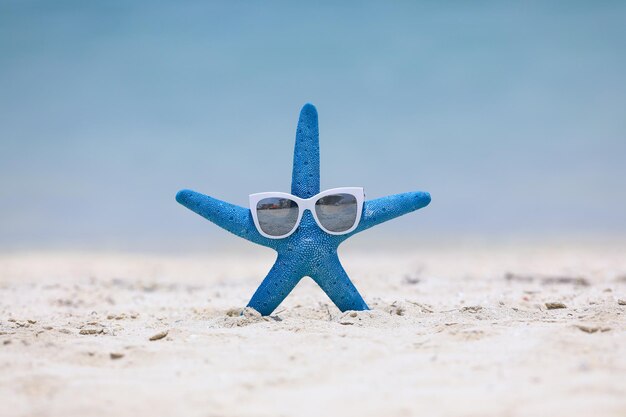 étoile de mer bleue et boisson sur fond d'été de sable de plage