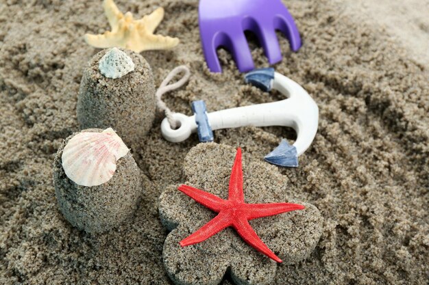 Photo Étoile de mer de sable en forme de fleur et en forme de château et gros plan de jouets pour enfants