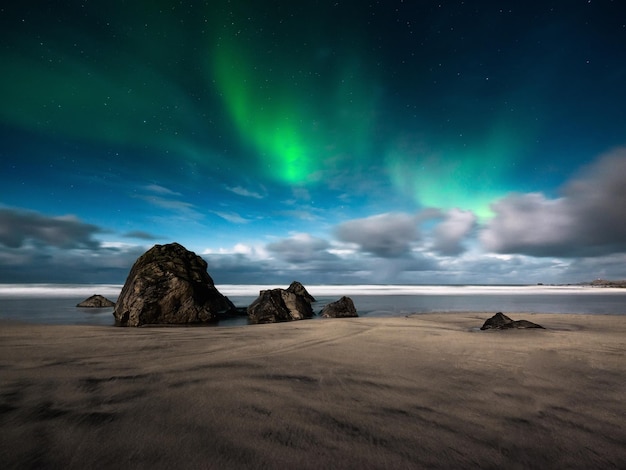 Étoiles et lumière du nord Aurora Borealis Skagsanden beach sur les îles Lofoten Norvège SGlow on sky Image Nature