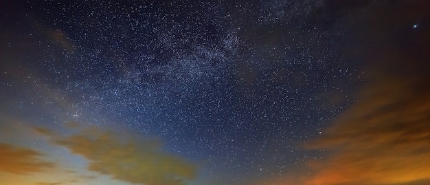 Les étoiles de la Voie lactée avec des nuages dans le ciel nocturne.