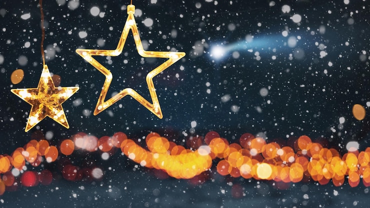 Photo étonnantes deux étoiles lumières de noël sur un fond de forêt d'hiver avec bokeh lumières dorées neige et un concept d'étoile filante bonne année et carte de noël idée créative