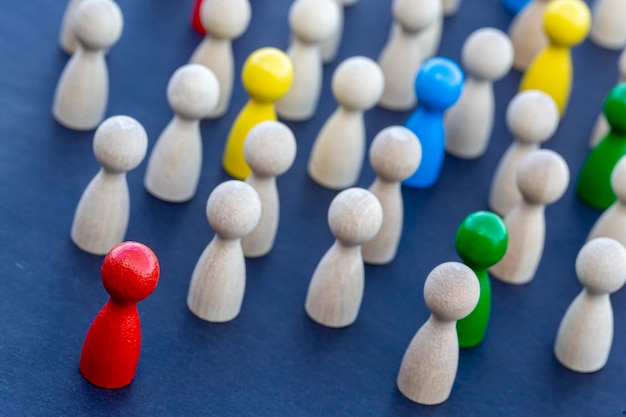 Être différent, être un leader, diriger. expression d'icône avec des figures en bois colorées. Concept de travail d'équipe, équipe de figurines en bois. Concept de travail d'équipe, équipe de figurines en bois.
