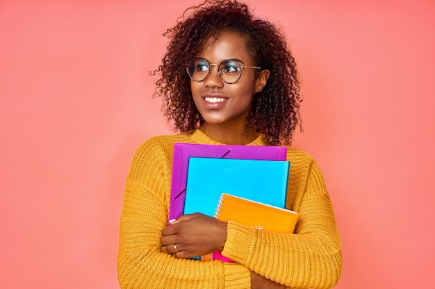 Photo un étudiant afro-américain joyeux et heureux qui rêve d'obtenir un diplôme porte des papiers et un bloc-notes