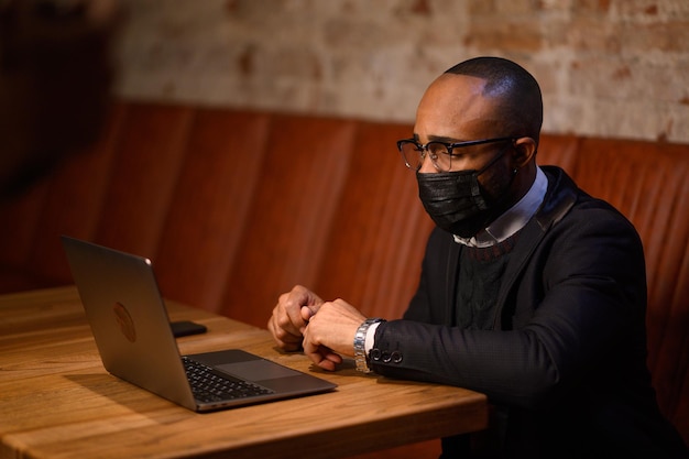 Un étudiant afro-américain travaille sur un ordinateur portable dans un café