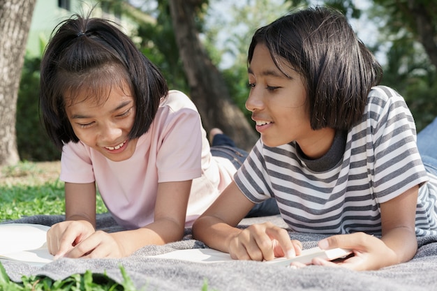 Étudiant Asiatique Heureux En Position Couchée Lire Le Livre Sur La Couverture En été