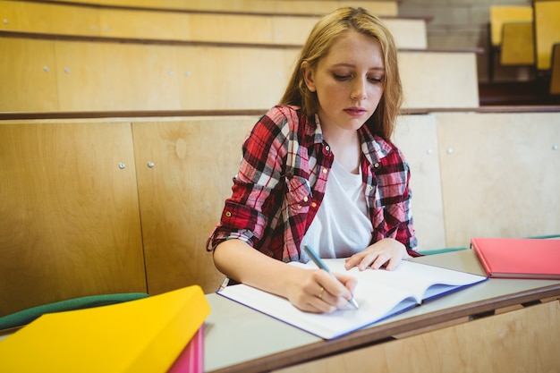 Étudiant ciblé prenant des notes pendant le cours